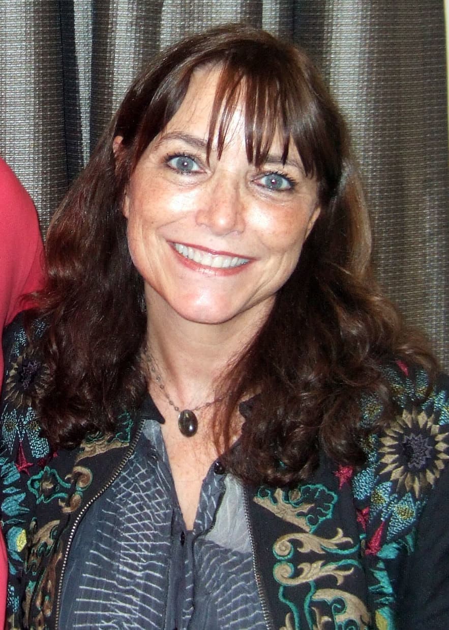 Karen Allen smiling, with long dark hair