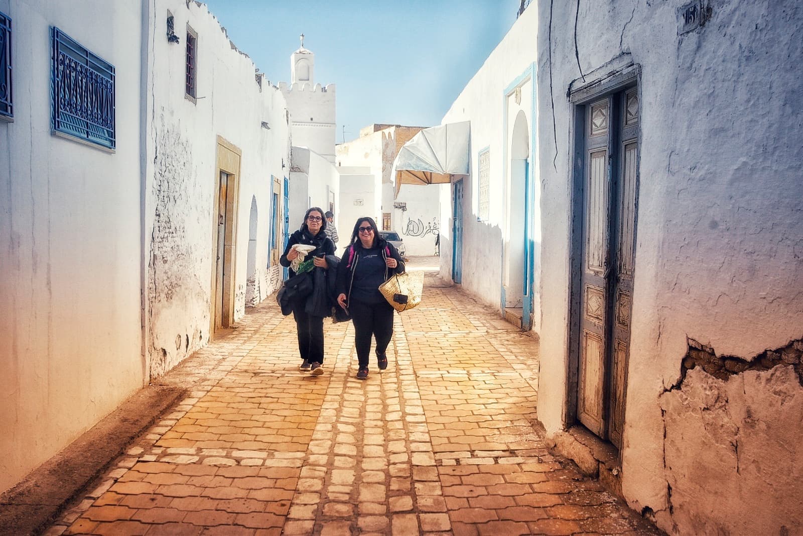 A narrow street of pale walls and doorways in the old town of Kairouan