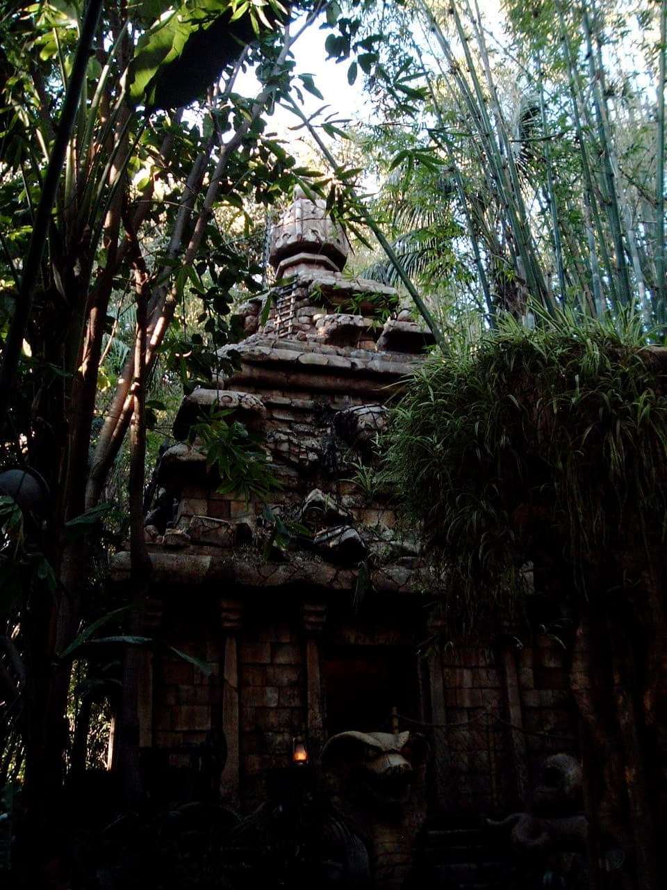 A carved stone temple front half hidden in jungle planting