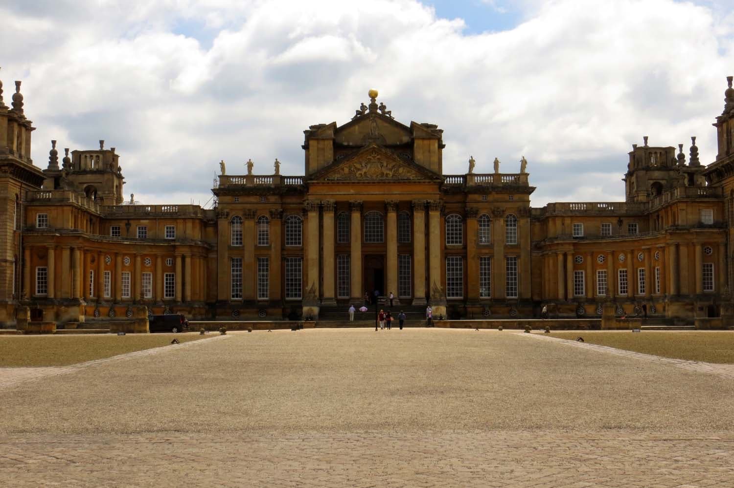 A vast baroque palace front across a wide gravel court
