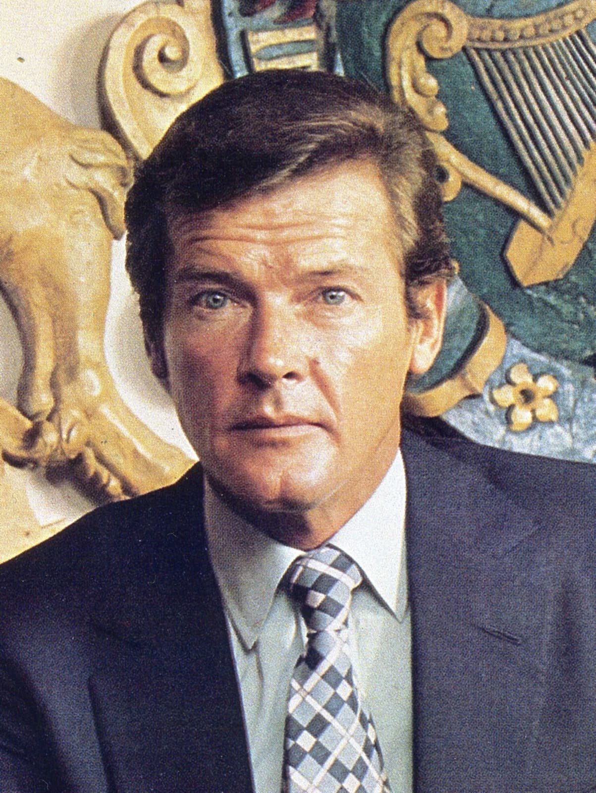 Roger Moore in a dark jacket and patterned tie