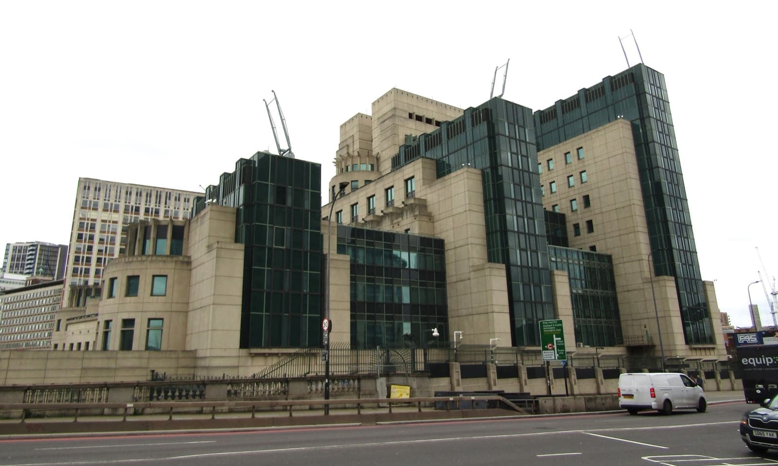 A stepped cream and green-glass building beside a road