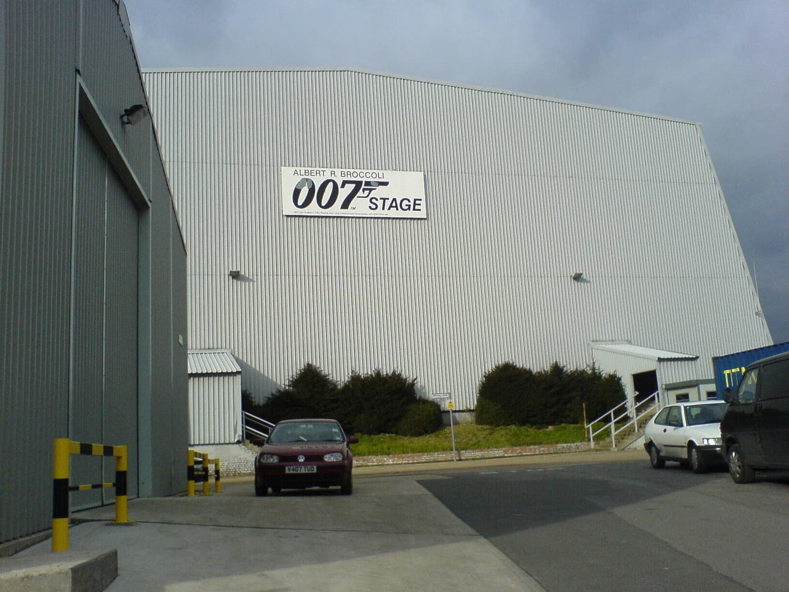 A huge white windowless studio building with a sign on its side