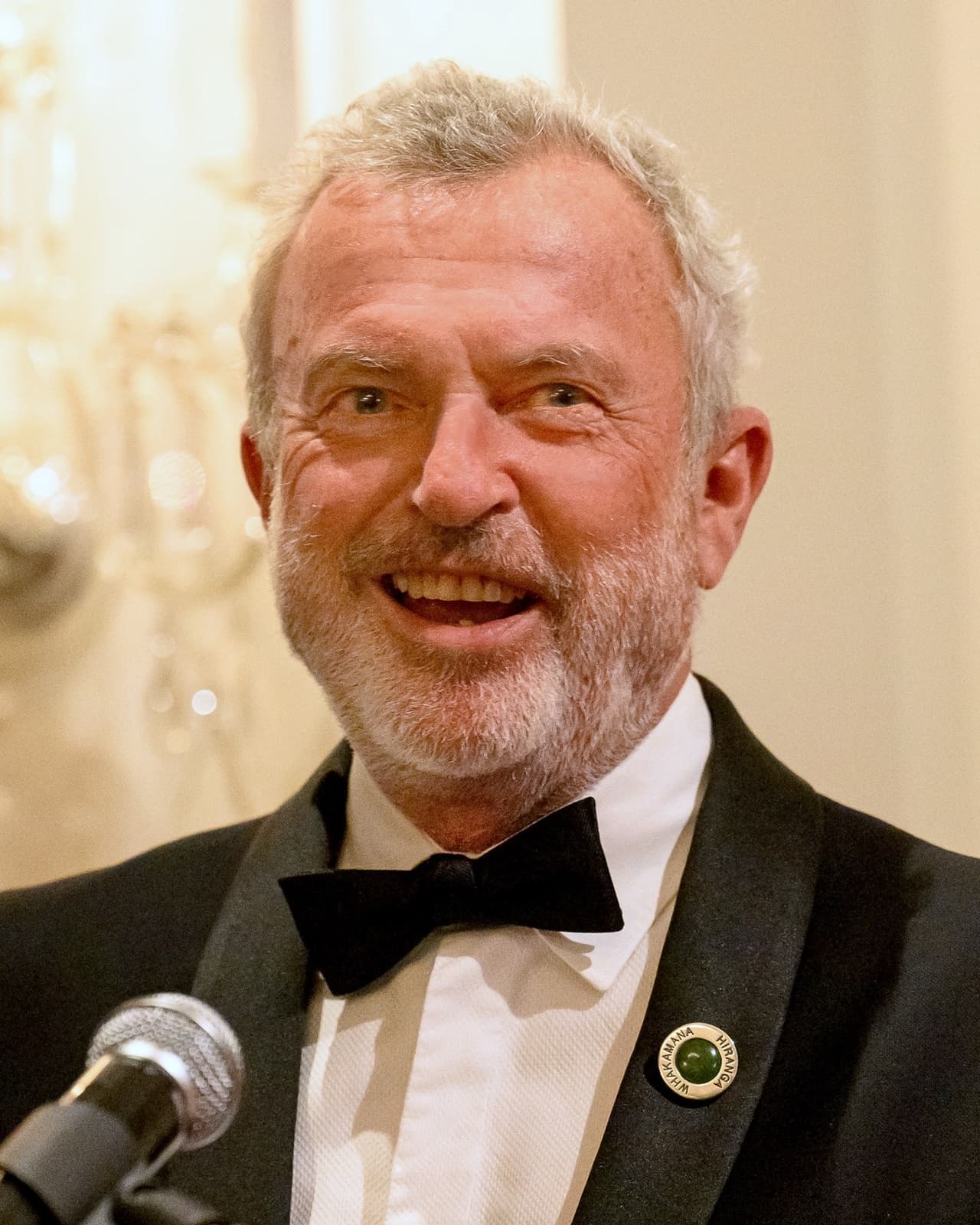 Sam Neill smiling, in black tie