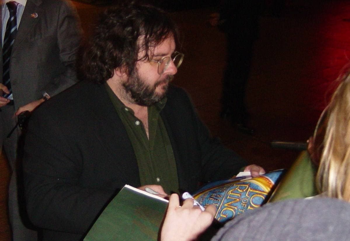 Peter Jackson with glasses and beard signs autographs