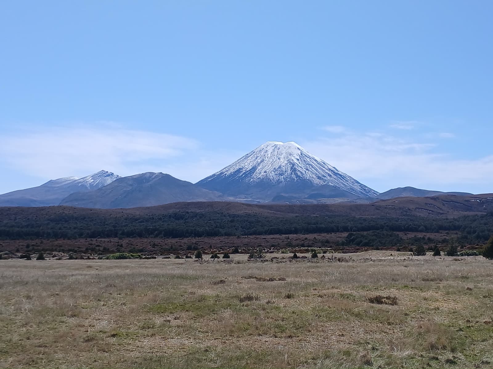 A symmetrical volcanic cone seen from a village