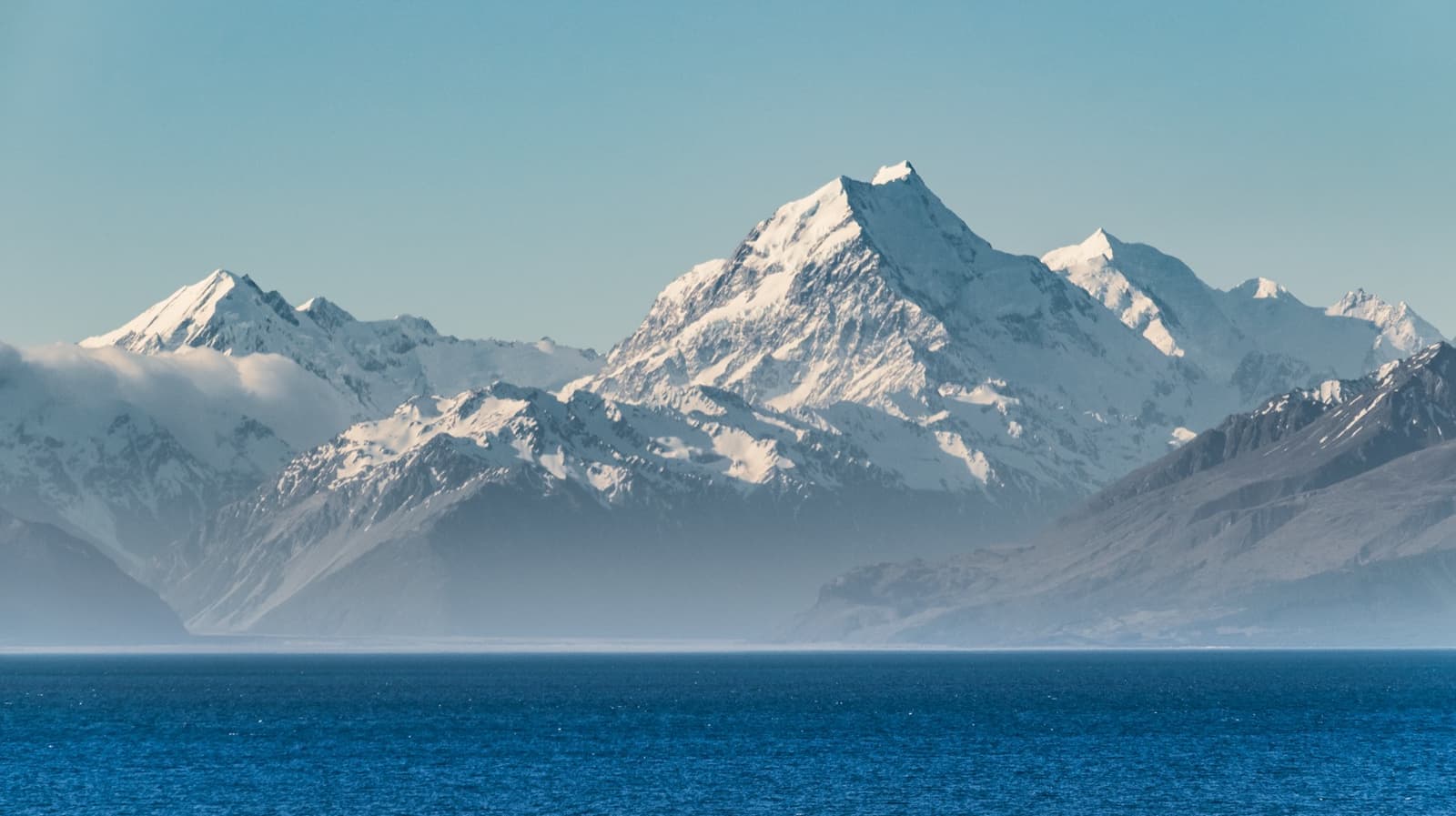 A turquoise lake with a snow-capped mountain beyond