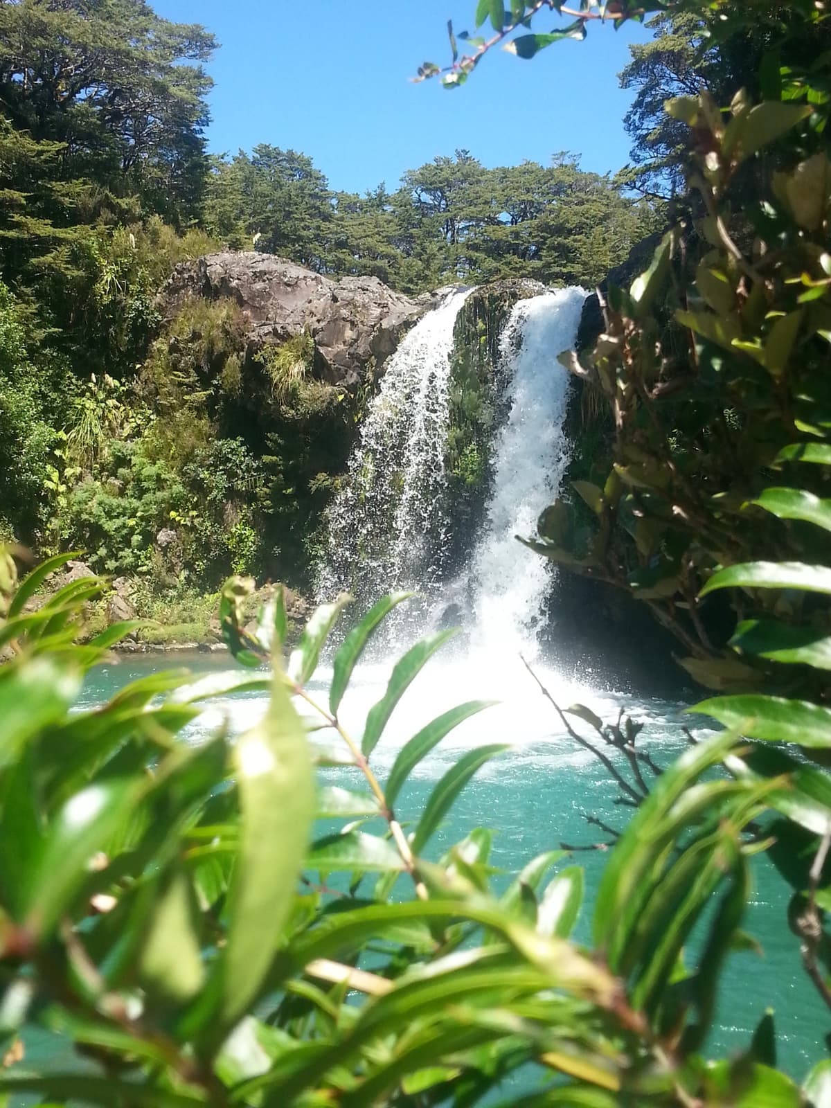 A waterfall dropping into a turquoise pool