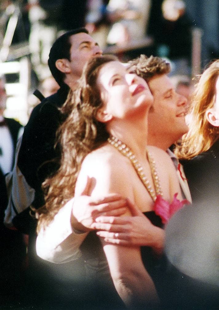 Liv Tyler looks up, laughing, beside Sean Astin in a crowd at night