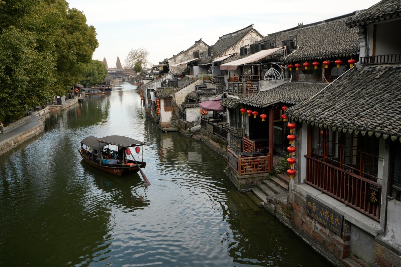 White-walled houses with dark roofs along a canal with boats