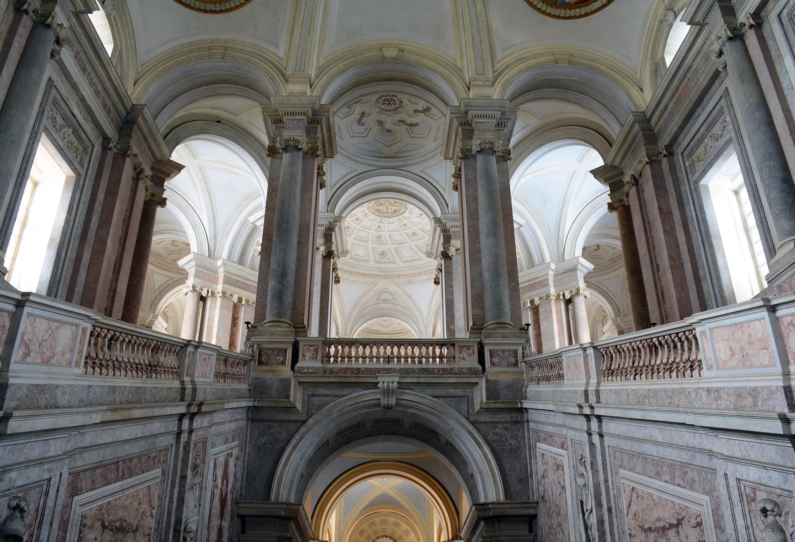 A vast marble staircase with lions and a vaulted ceiling