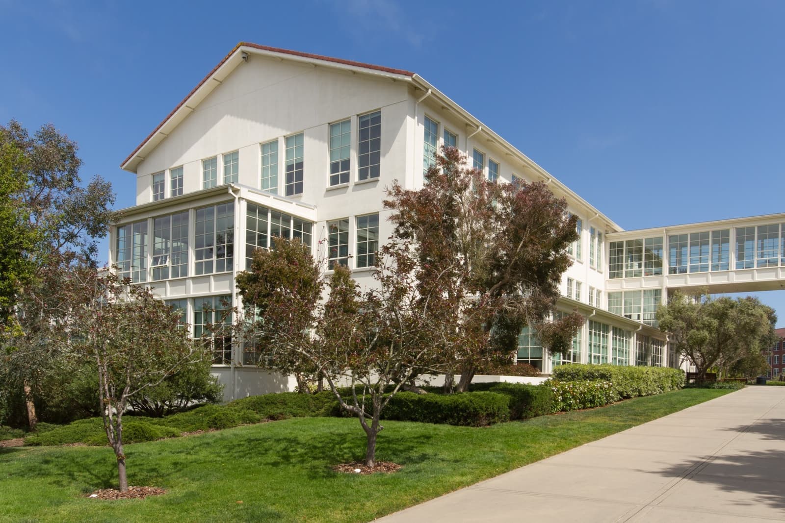 A brick office building behind trees and lawns in the Presidio