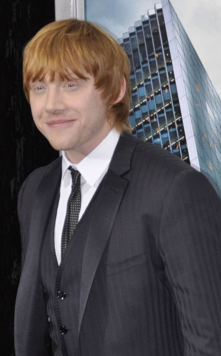 Rupert Grint in a pinstriped suit, smiling