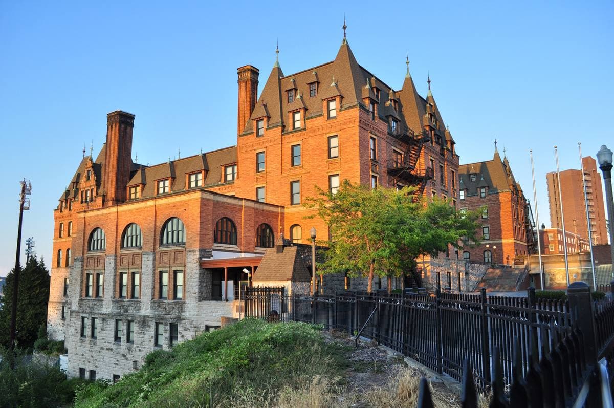 Stadium High School's brick towers and slate roofs lit by low sun