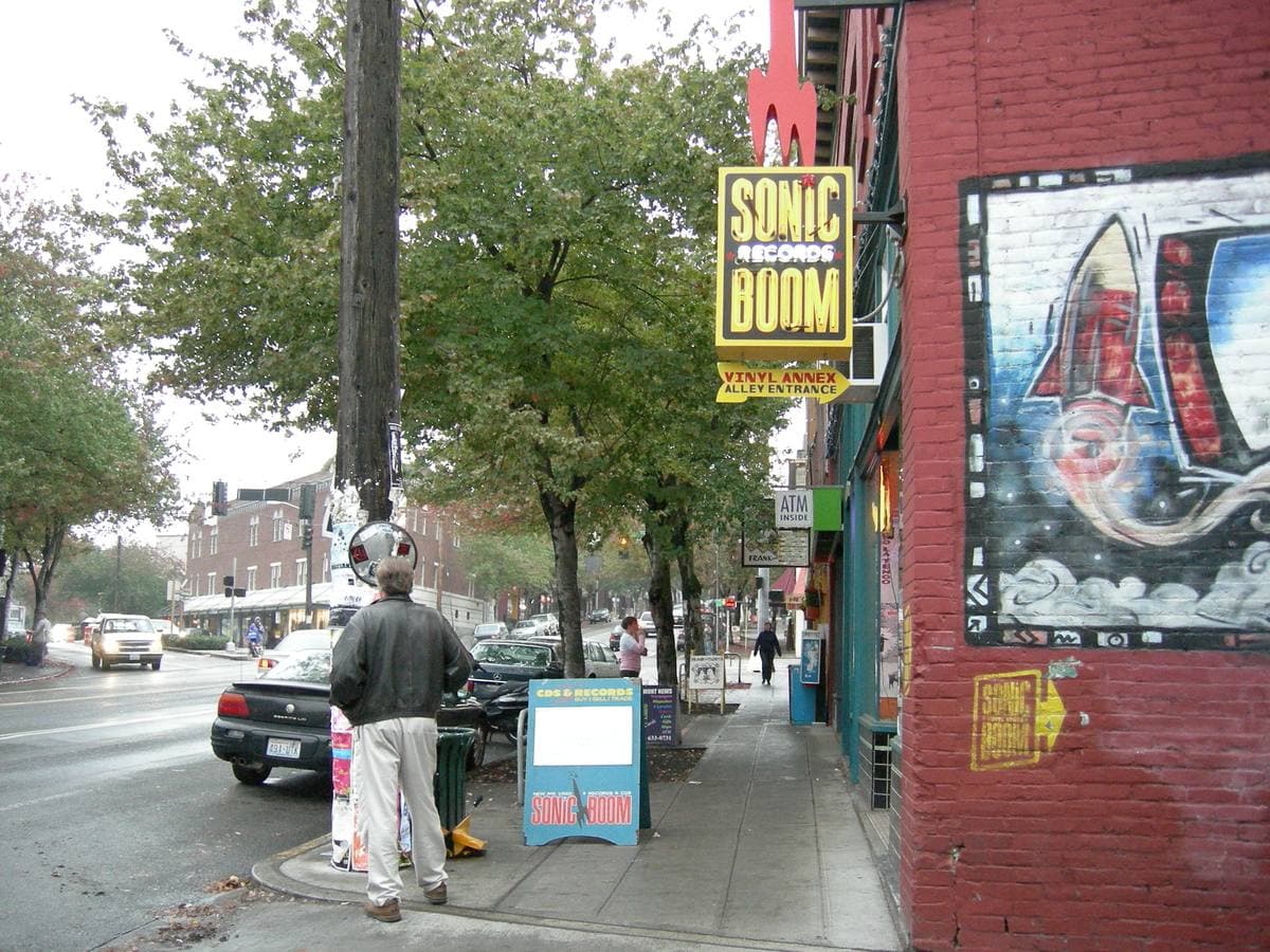A Fremont street corner with a record shop sign and a mural