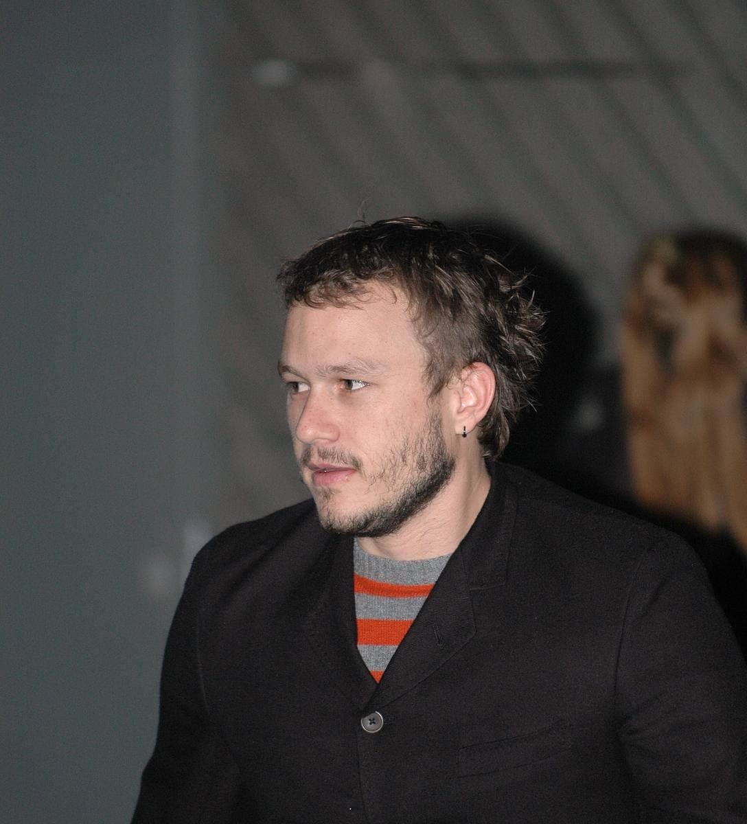 Heath Ledger in a dark jacket and striped jumper