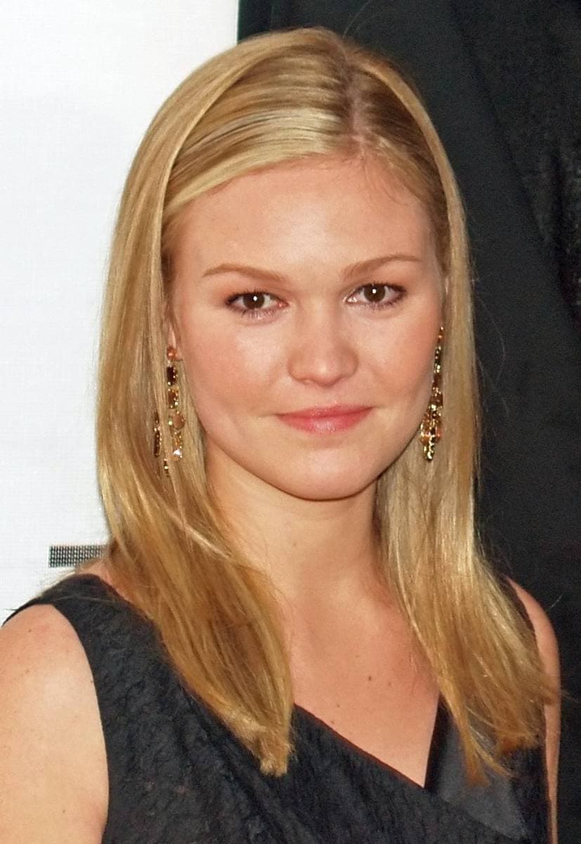 Julia Stiles smiling, with long blonde hair