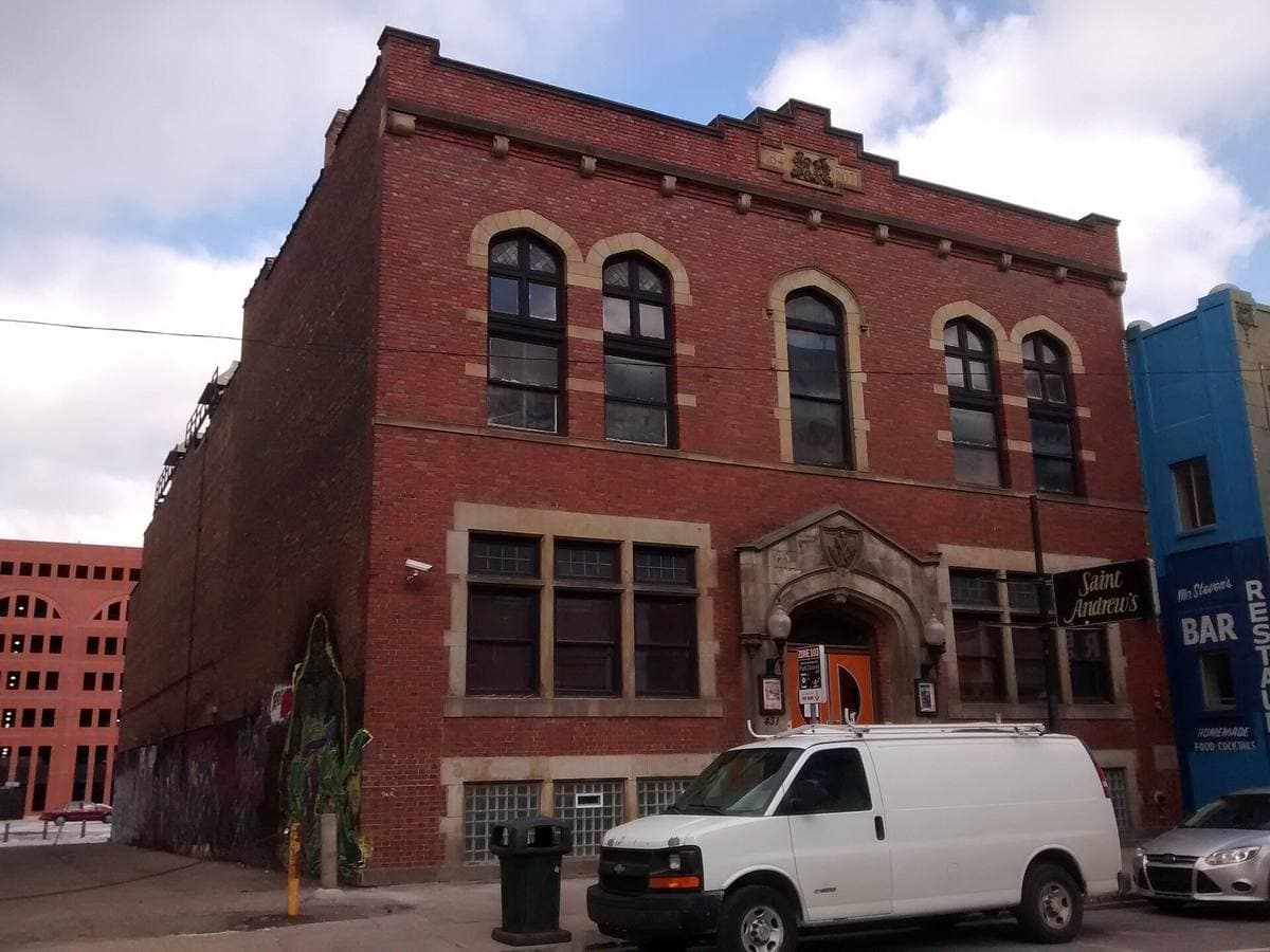 A red-brick hall of 1907 on a downtown Detroit street corner, its name over the door