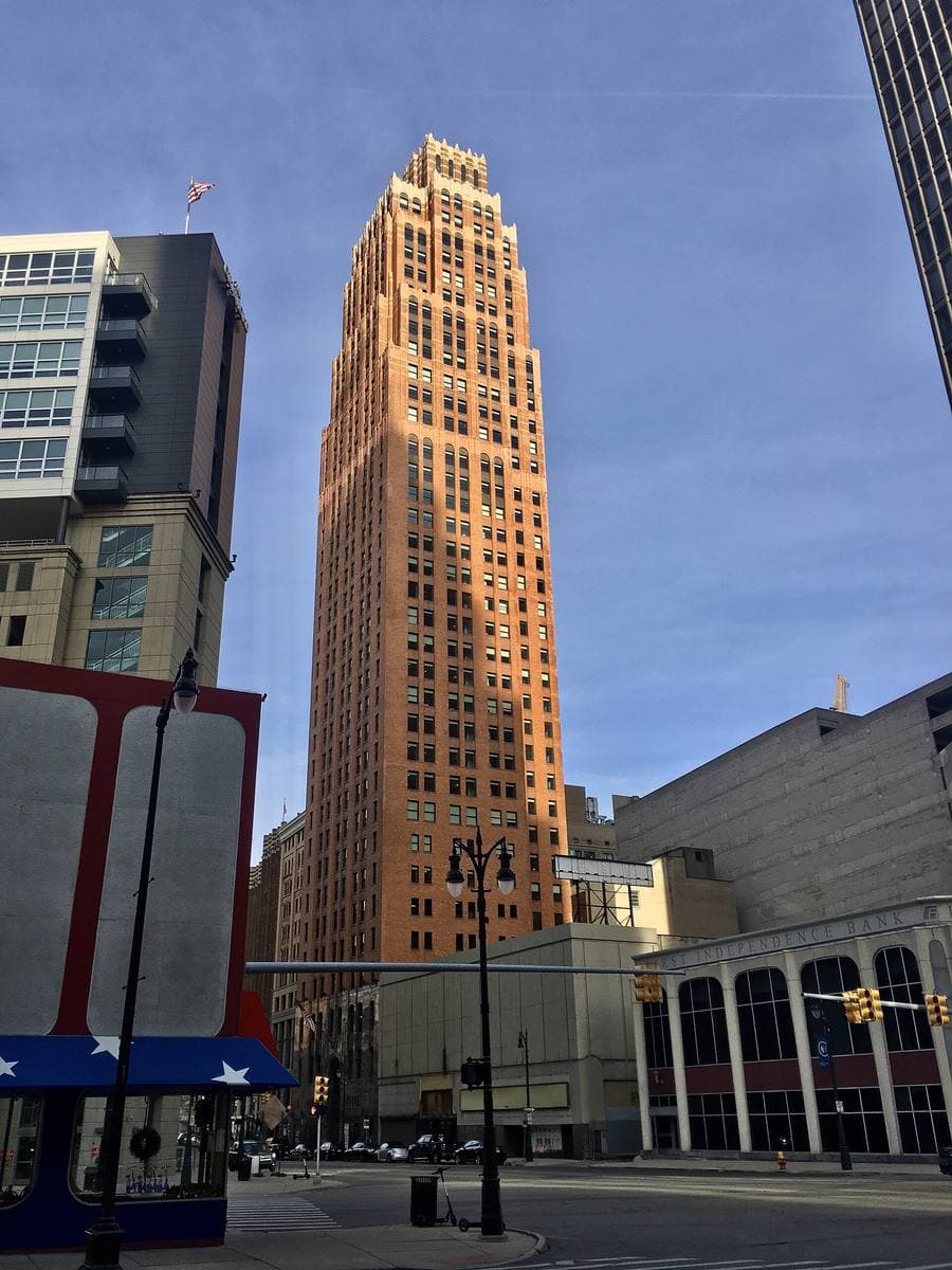 Griswold Street lined with old office buildings, the tall stepped David Stott Building at the end