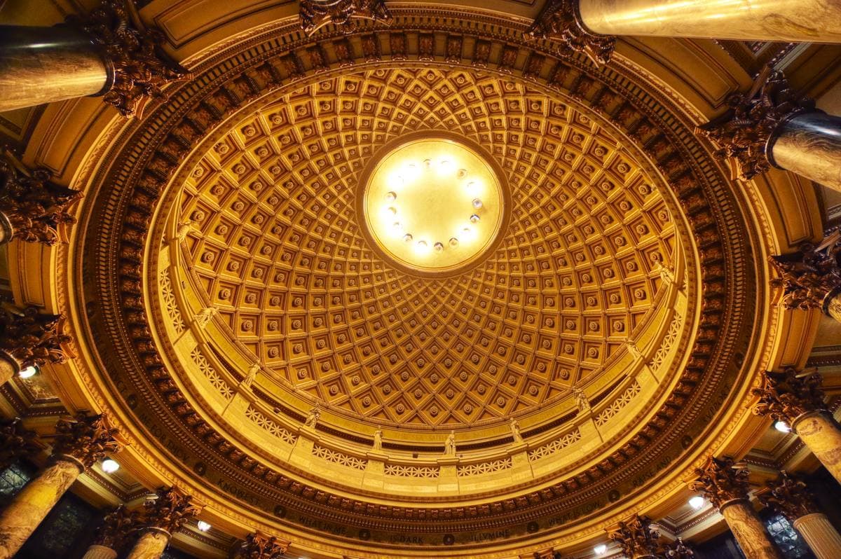 A coffered golden dome with a round oculus at its centre