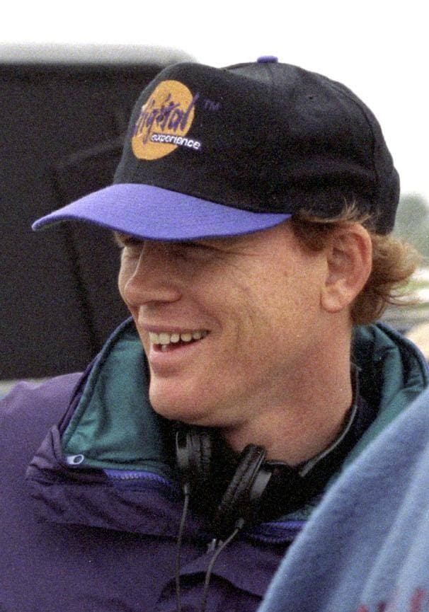 Ron Howard smiling in a baseball cap and headphones on a film set