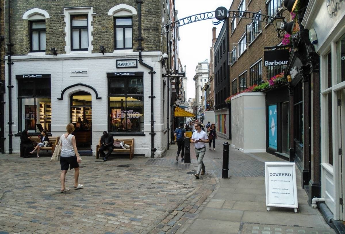 A narrow cobbled street of small shopfronts