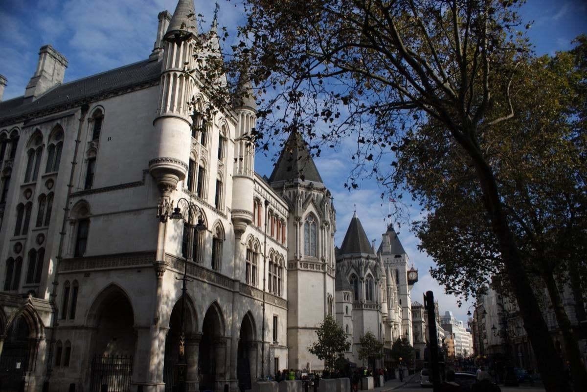 A Gothic stone front with towers and arched doors over a busy street