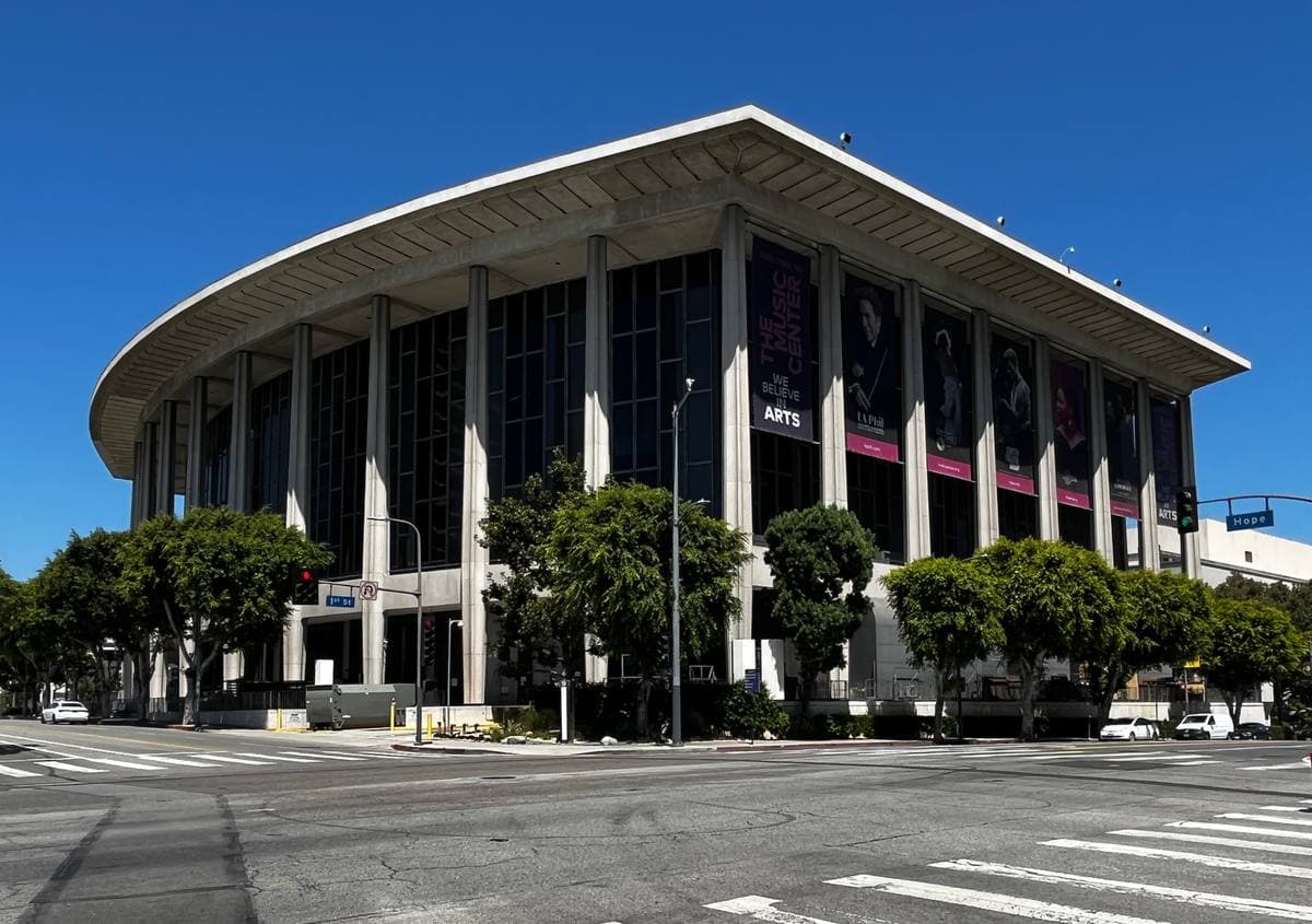 A curved white colonnaded concert hall on a sunny Los Angeles corner