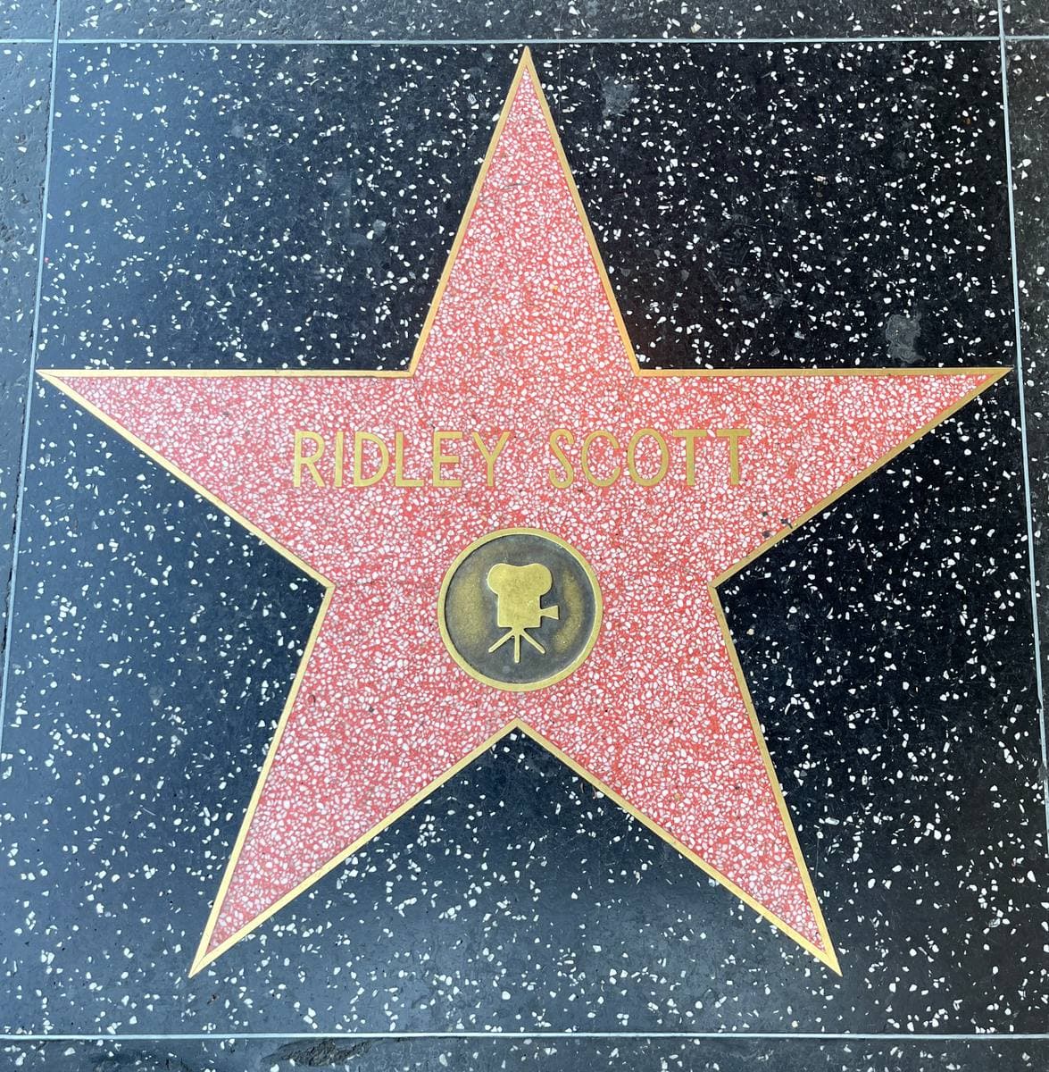 A pink terrazzo star with a brass camera emblem and the name Ridley Scott