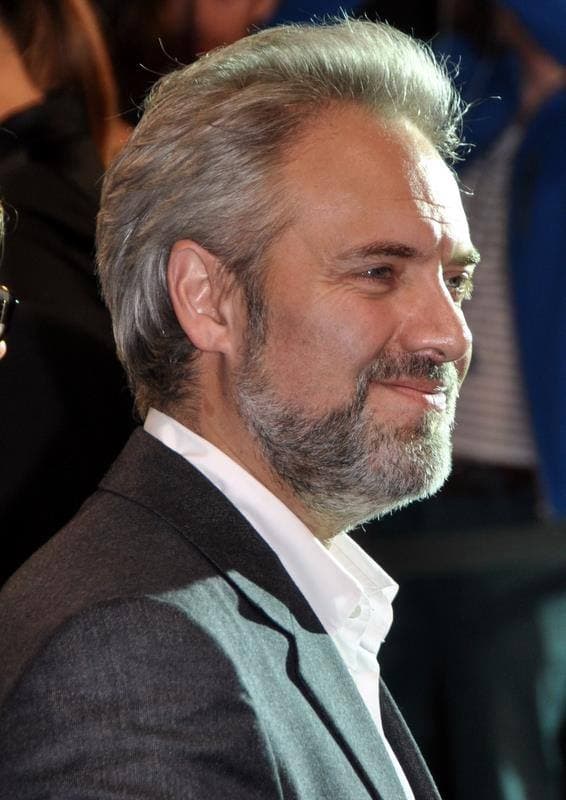 Sam Mendes in a dark suit at a premiere