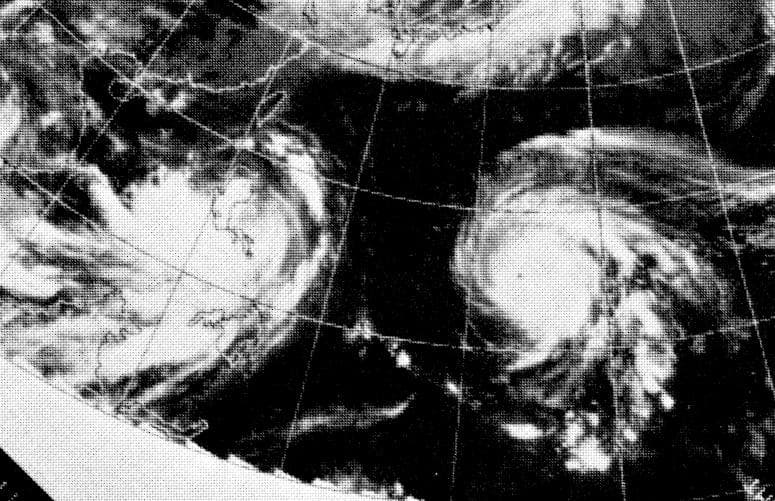 Black-and-white satellite picture of two spiralling storms over the western Pacific