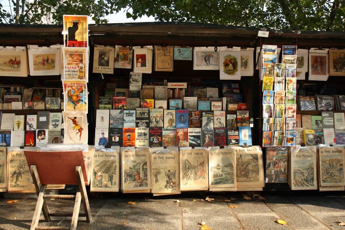 Open green bookstalls hung with prints and old books