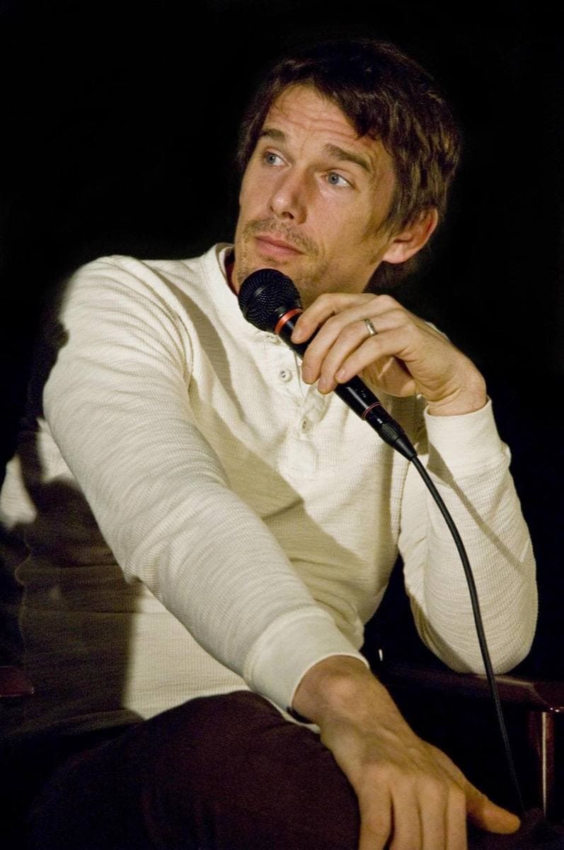 Ethan Hawke seated with a microphone, in a cream jumper