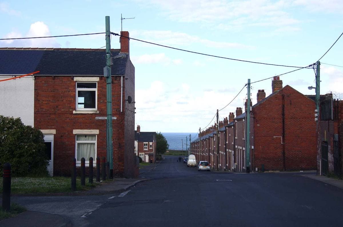 A terraced street running downhill to a glimpse of the sea