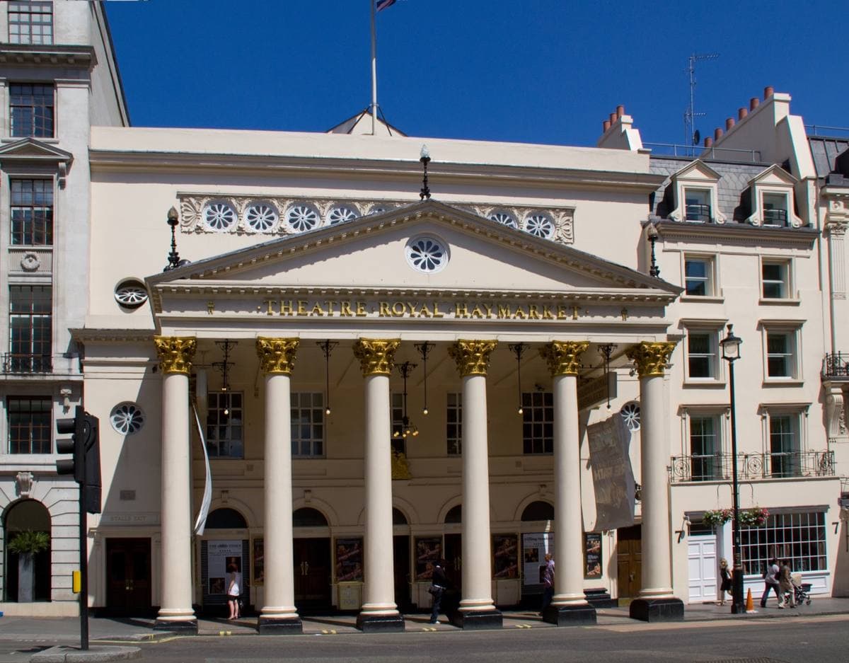 A white theatre portico of six columns on a London street