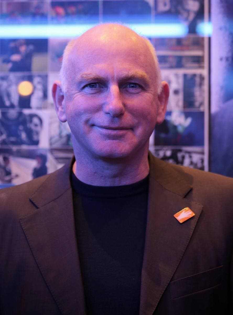 Gary Lewis smiling in a dark jacket