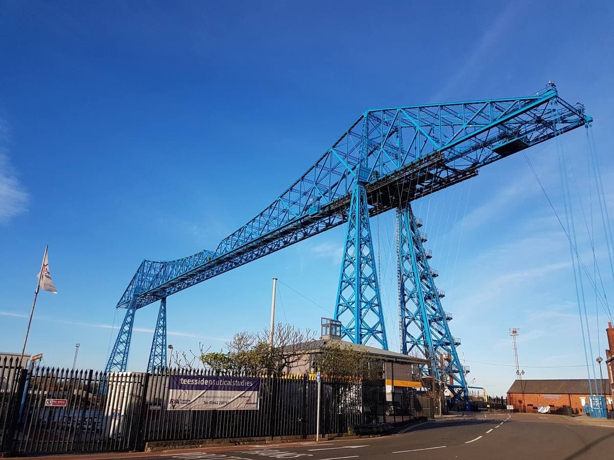 A blue steel transporter bridge against a deep blue sky