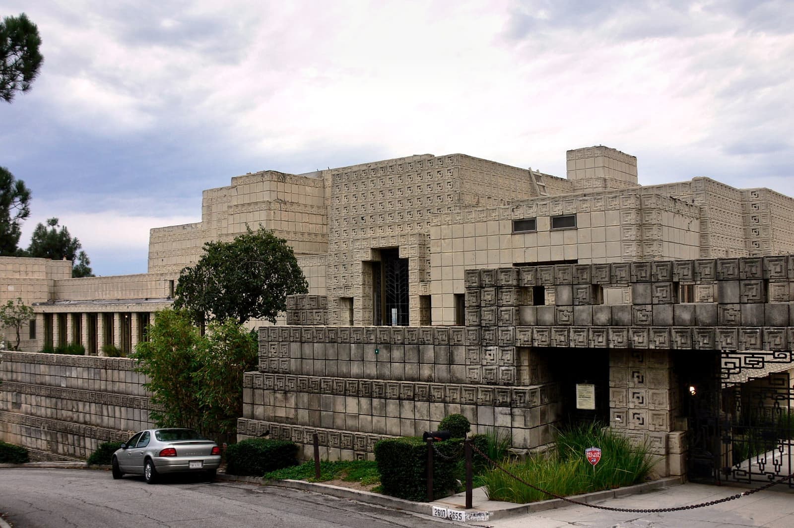 A long low house of patterned concrete blocks on a hillside