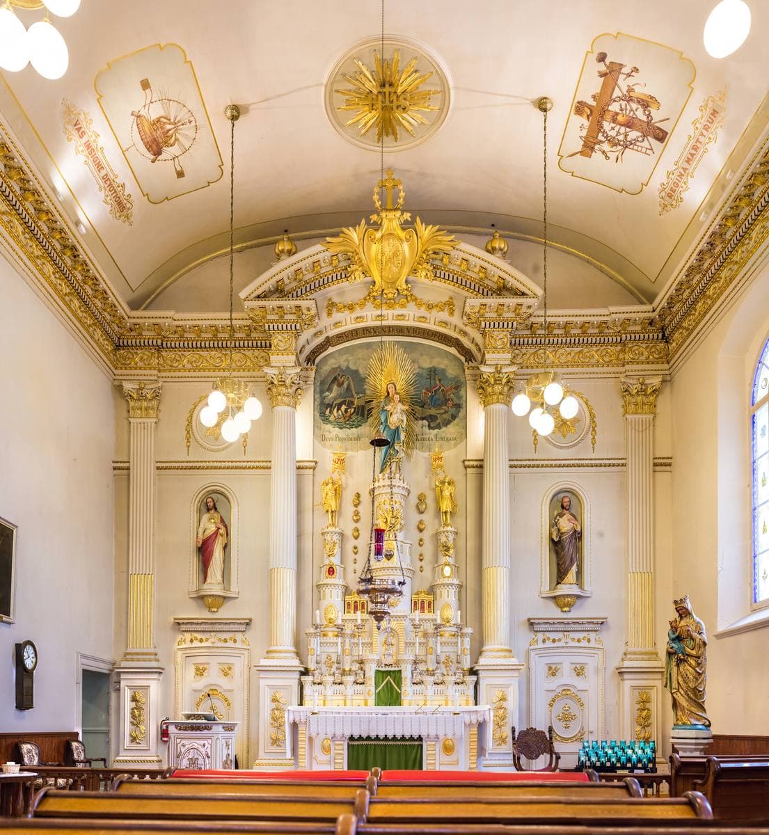 A white and gold church interior with a castle-shaped altarpiece