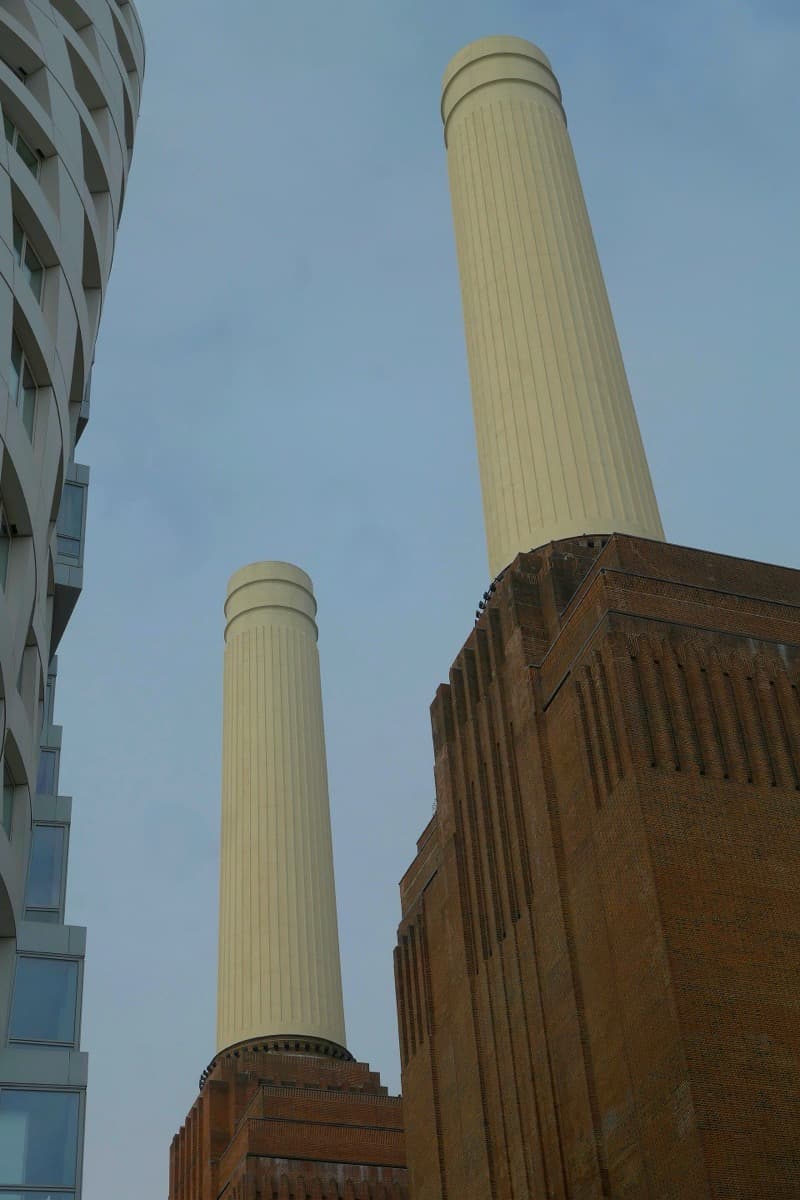 The four white chimneys of Battersea Power Station against a grey sky
