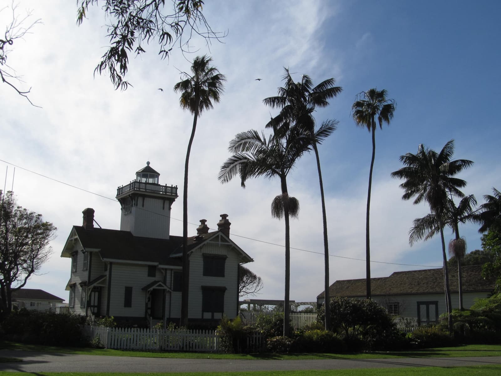 A Victorian wooden lighthouse among palm trees