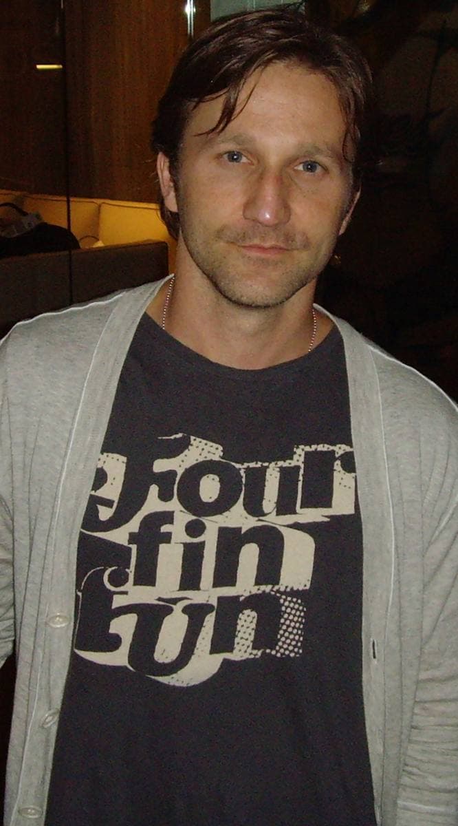 Breckin Meyer standing in a suit