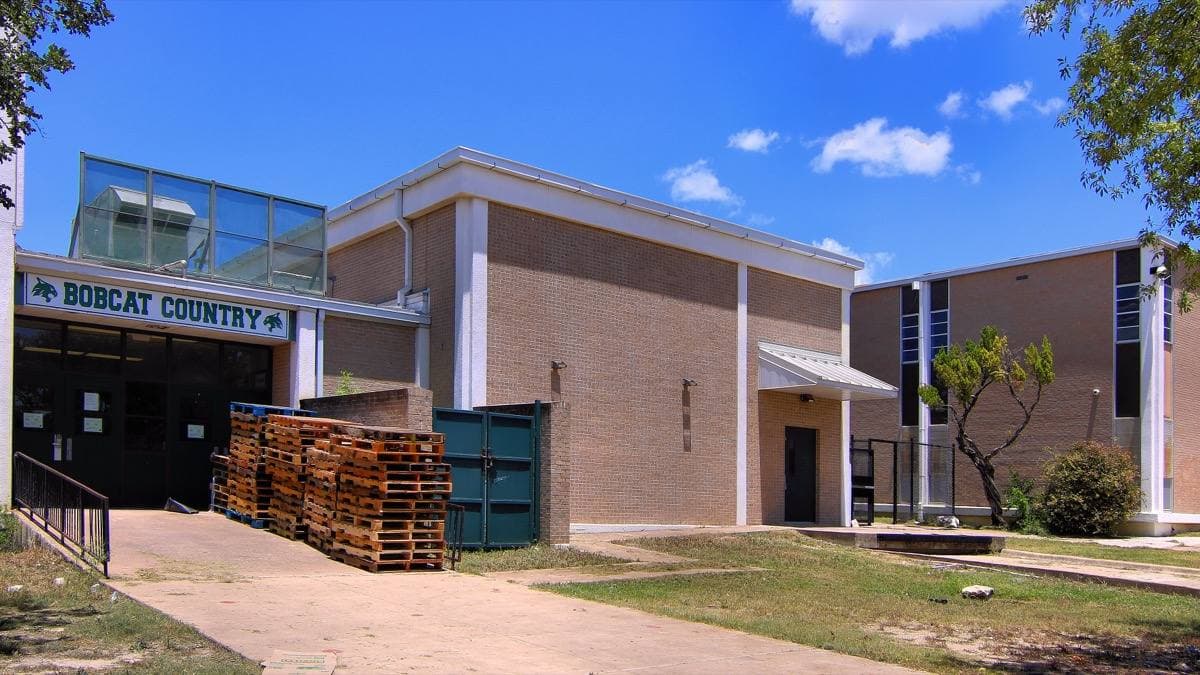 A low brick school building with a blue Bobcat Country sign above the doors