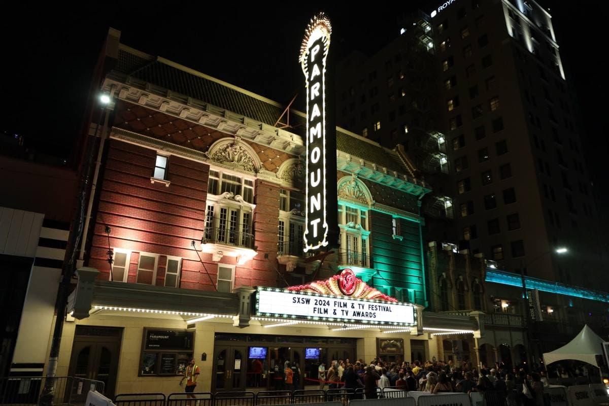 The lit marquee and vertical sign of the Paramount Theatre at night