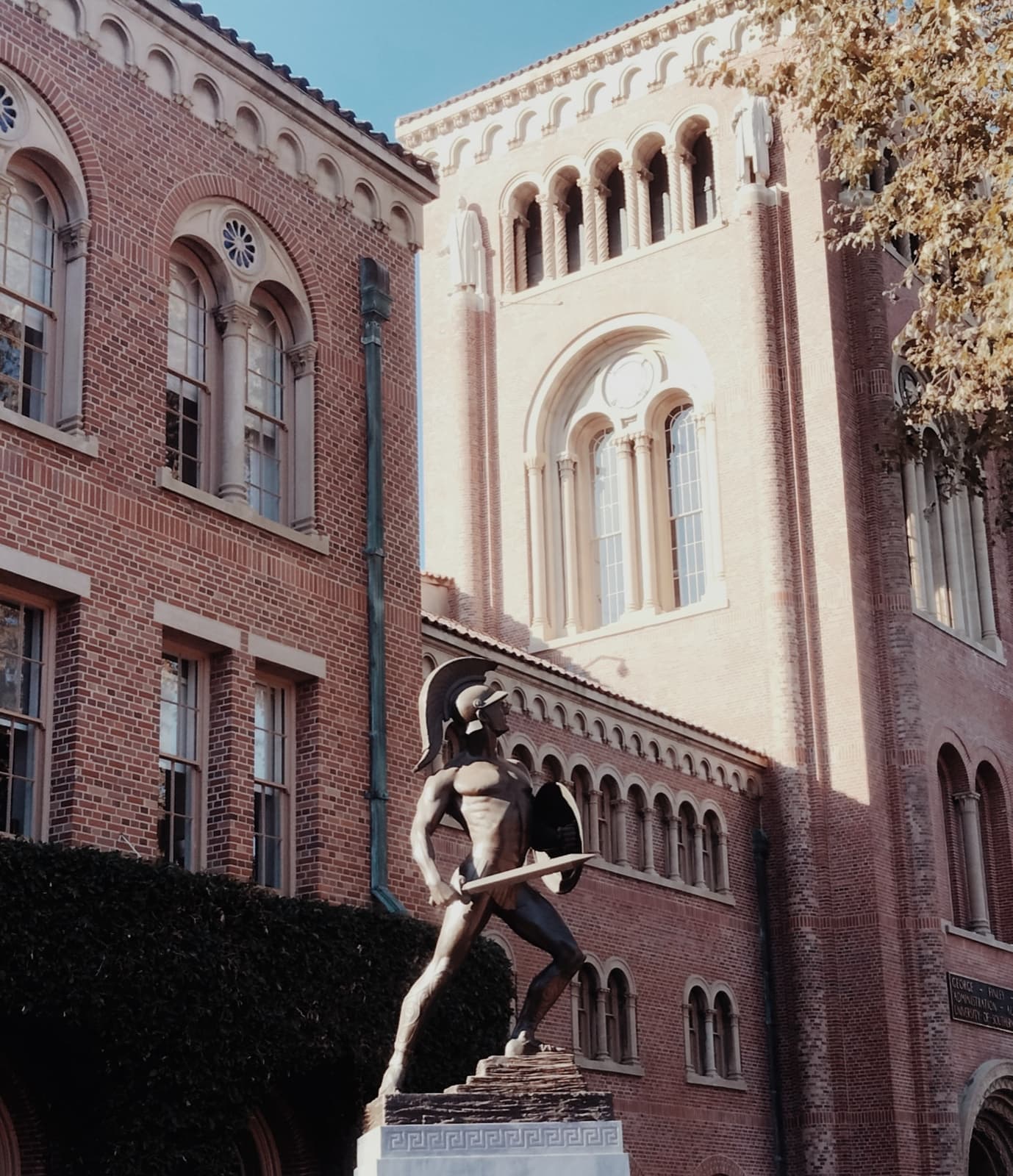 A bronze Trojan warrior statue on a stone plinth
