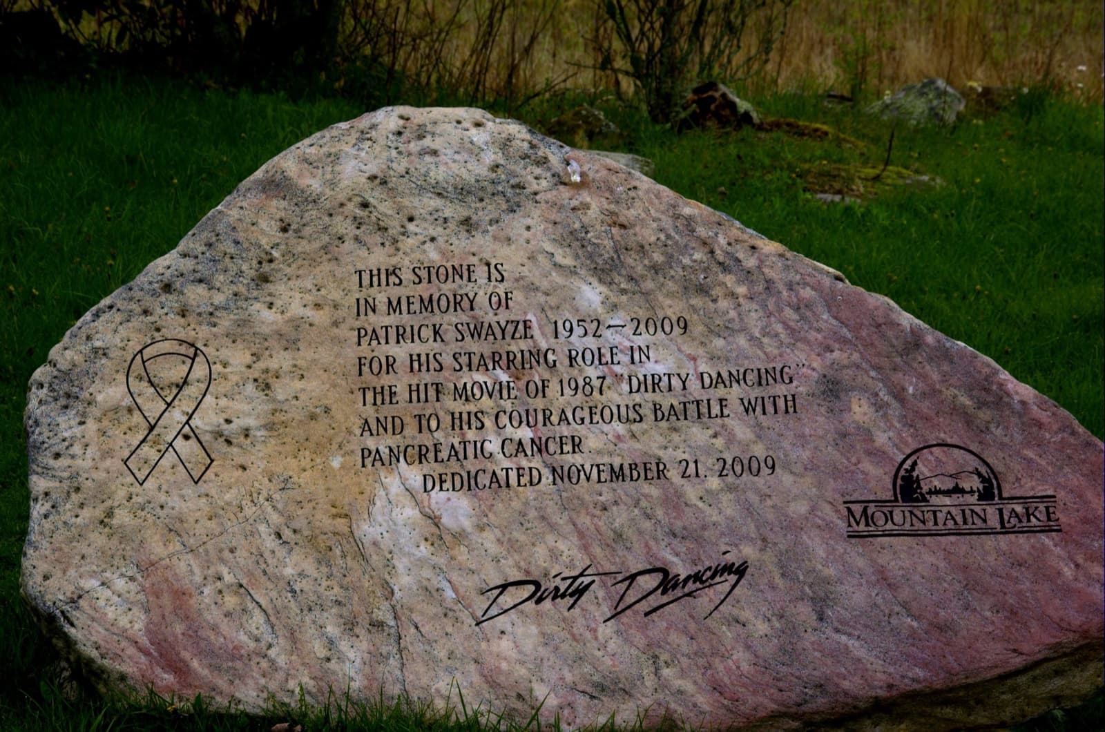 A pink granite boulder carved with a ribbon, a dedication and the words Dirty Dancing