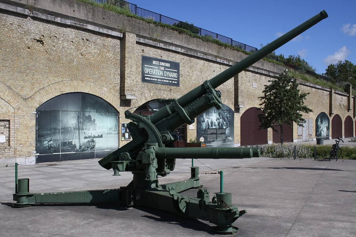 Brick casemates with arched openings, an old anti-aircraft gun in the yard in front