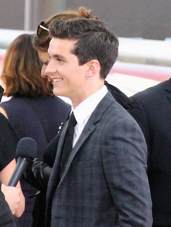 Fionn Whitehead, a young man with dark hair, in a dark suit