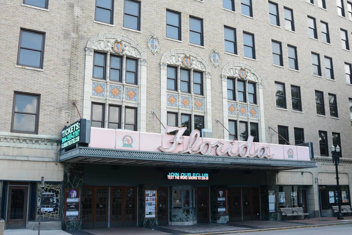 A cream terracotta theatre front with a pink neon marquee reading Florida
