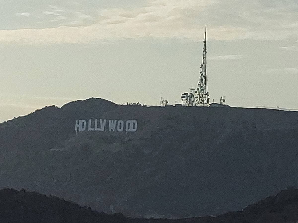The white Hollywood letters on a brown hillside under a clear sky